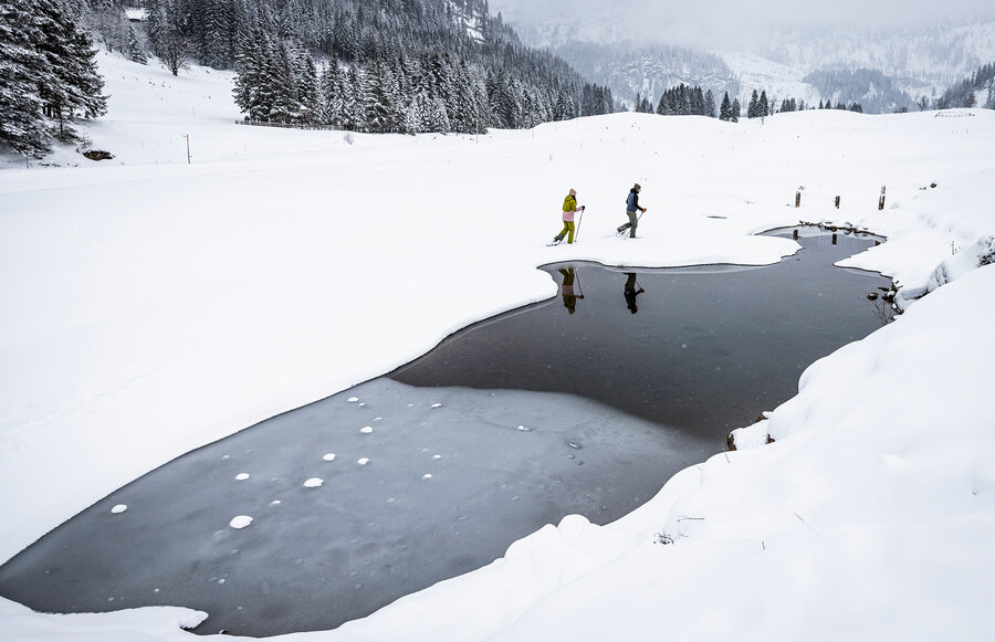 Personen mit Schneeschuhen unterwegs im tiefen Schnee.