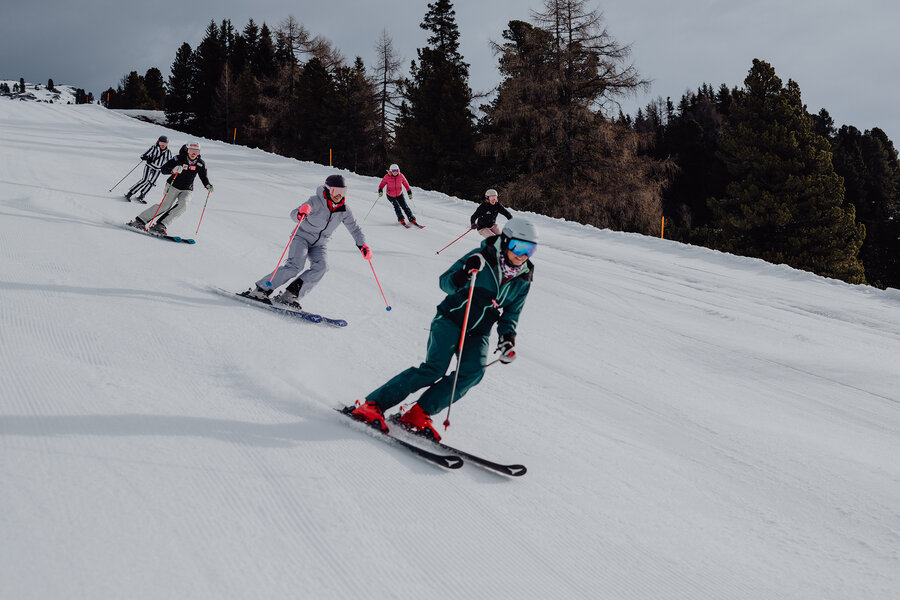 Skigruppe bei gemeinsamer Abfahrt auf der Piste