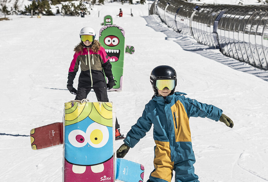 Kinder lernen spielerisch das Skifahren auf der Übungspiste in Obertauern.