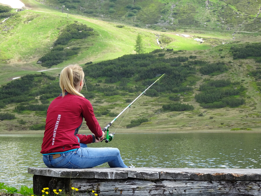 Frau beim Fischen am Hundsfeldsee in Obertauern.