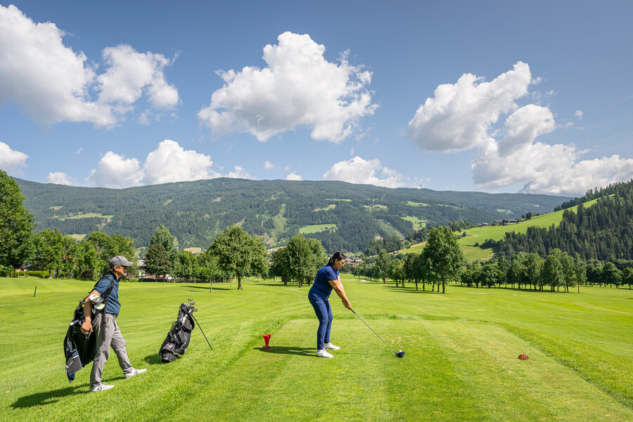 Golfer auf einem Golfplatz in alpiner Landschaft