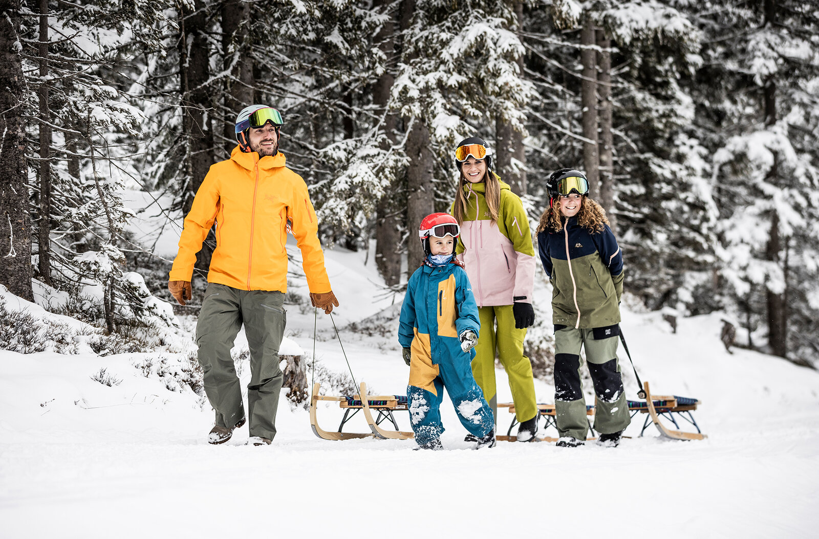 Familie genießt das Rodeln in der schneebedeckten Landschaft von Obertauern.