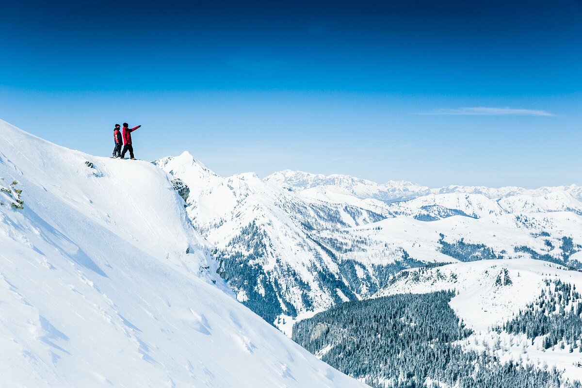 Zwei Snowboarder bestaunen die Landschaft beim Freeriden.