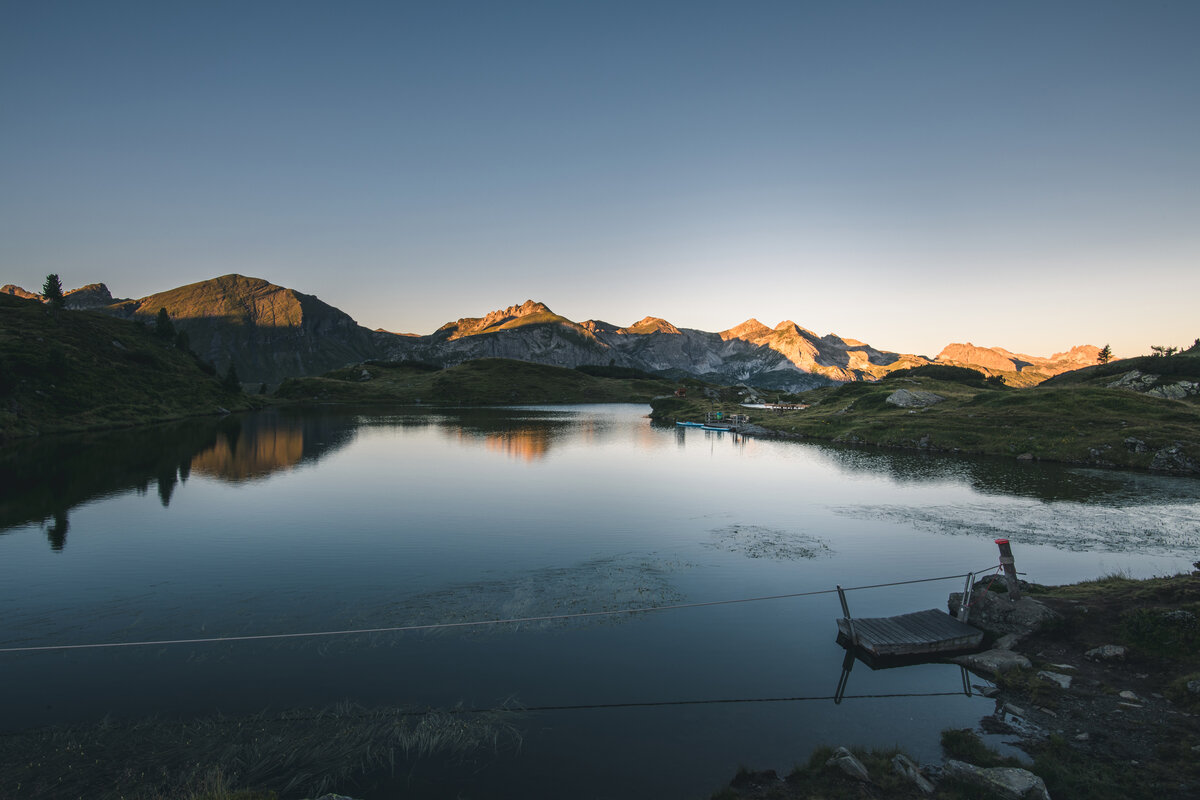 Krummschnabelsee in Obertauern mit Bergen im Hintergrund bei Sonnenuntergang.