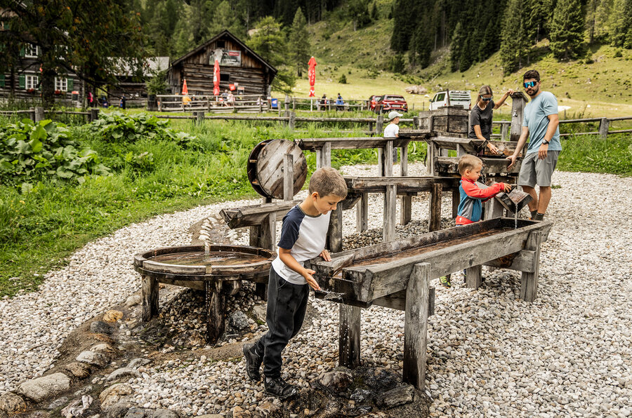 Familie spielt am Wasserspielplatz auf der Gnadenalm.