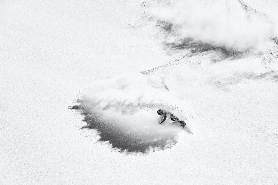 Snowboarder beim Freeriden im tiefen Pulverschnee.
