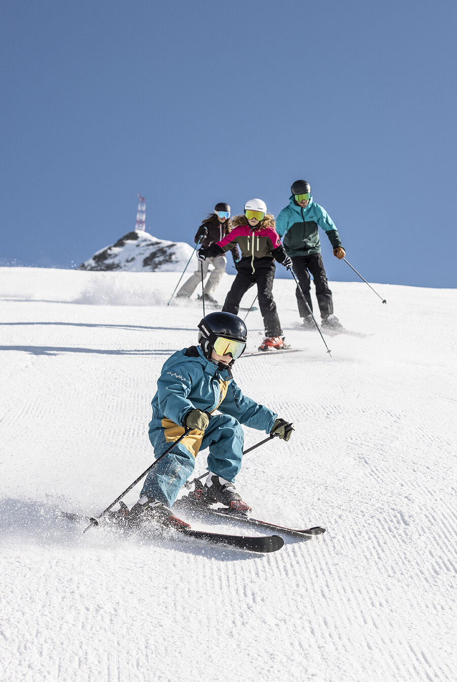 Familie beim Skifahren auf frisch präparierten Pisten in Obertauern.