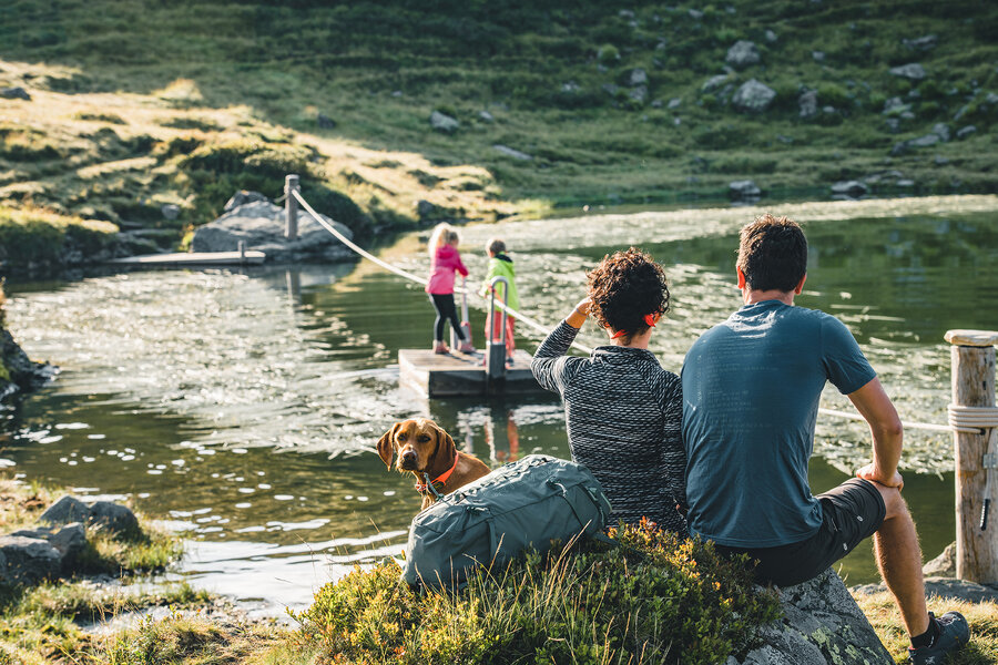 Kinder spielen auf einem Floß im Wasser.
