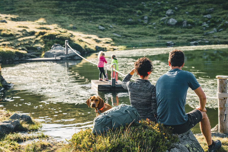 Kinder spielen auf einem Floß im Wasser.
