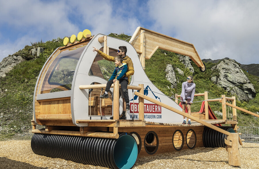 Familie spielt am Pistenraupen-Spielplatz in Bobbys Erlebniswelt