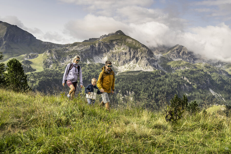 Zwei Wanderer mit ihrem Kind in alpiner Landschaft in Obertauern