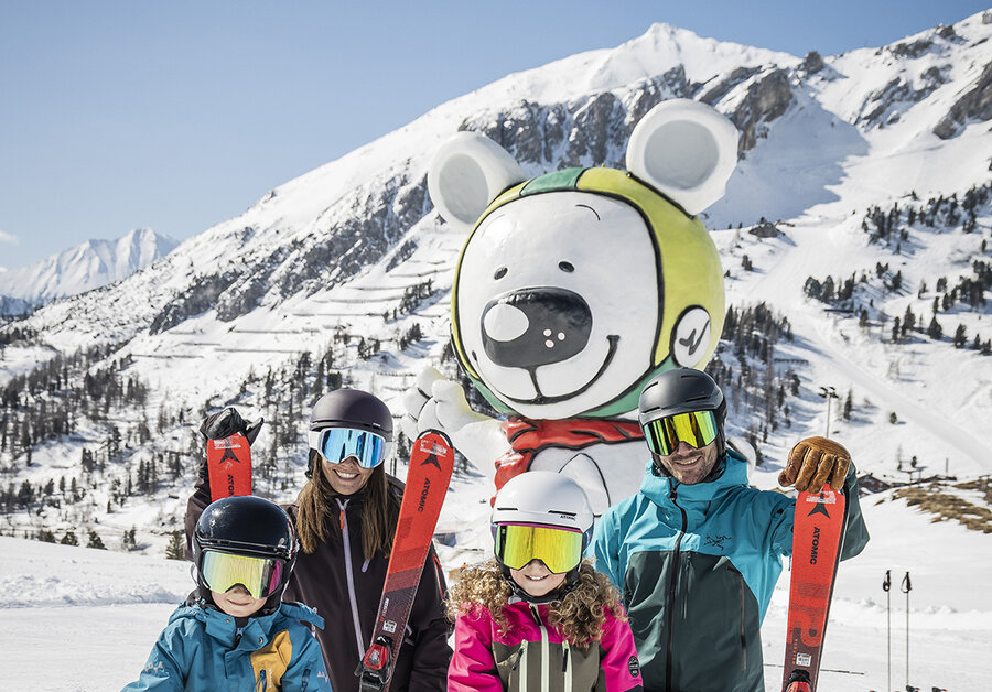Familie posiert vor der Bibo-Bär-Statue in Obertauern.
