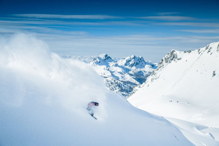 Freeride-Snowboarder unterwegs im unberührten Tiefschnee.