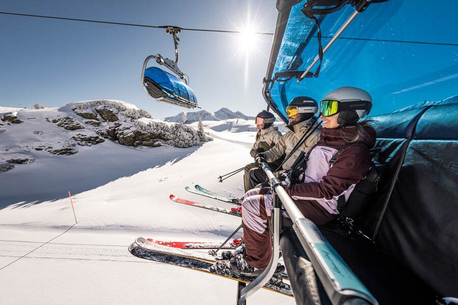 Skifahrer unterwegs mit der Seilbahn zur Bergstation.